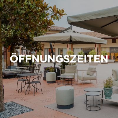 L'immagine mostra una parte del Franciacorta Designer Village. L'immagine riporta inoltre il titolo “Orari di apertura” in tedesco.